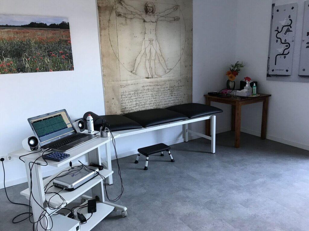 Besprechungszimmer in unserer Privatpraxis mit einer Liege und einem Laptop zur Erhebung von Untersuchungswerten